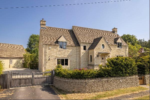 A stunning Cotswold stone home with outbuildings and mature gardens in 1.8 acres.