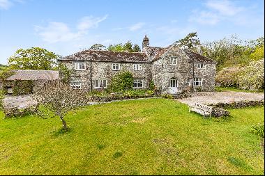 A medieval manor house set within a secluded wooded valley with a separate cottage, histor