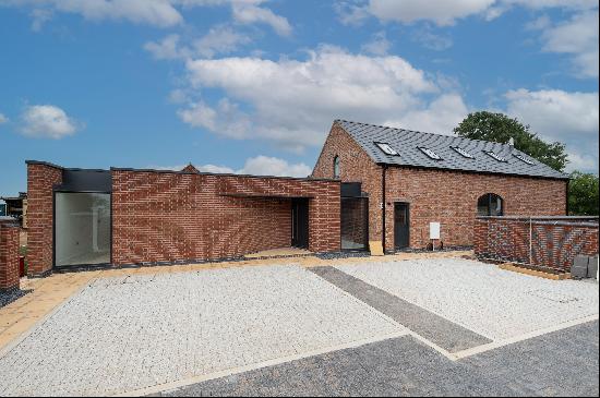 A converted traditional brick farm building with a contemporary design in an elevated loca