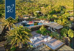 Eight typical buildings made of lava stone with pools inside a private area with gardens