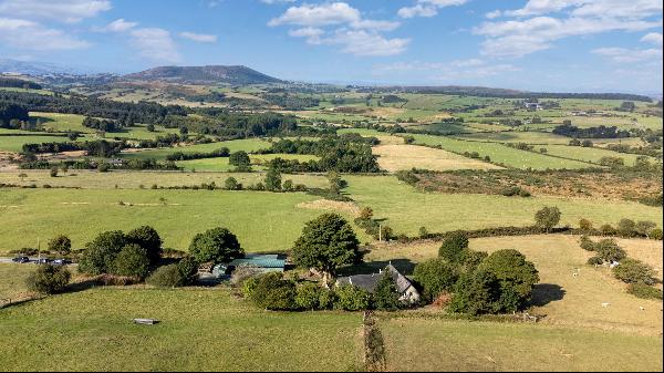 A detached four-bedroom house with far-reaching westerly views, set in 9.3 acres with stab