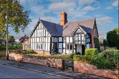 A handsome period village house in need of renovation standing in generous grounds.
