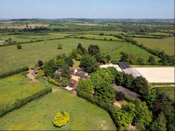 A large converted barn with a detached cottage and a self-contained wing surrounded by its