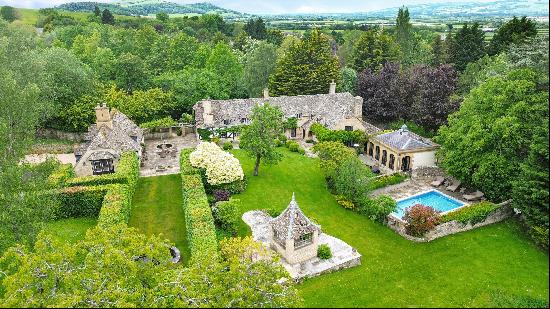 An immaculate Grade II listed Cotswold house, set in beautiful gardens with distant views.