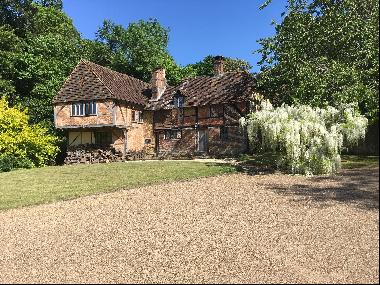 An historic village house with grounds abutting the River Wey.