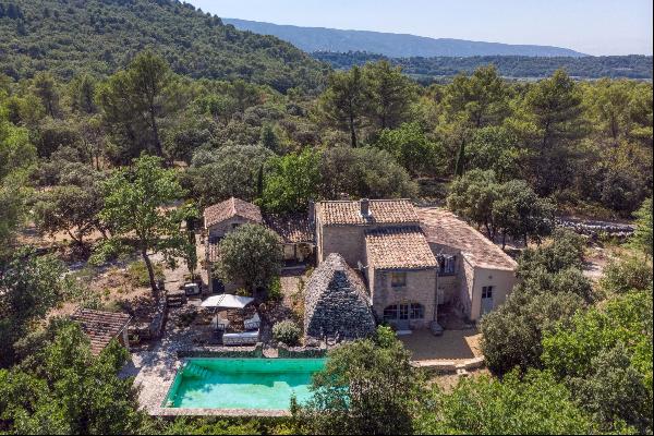 Pretty stone property, set in over 2 hectares of land with views over the village of Méner