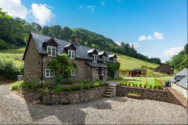 A striking extended Welsh stone cottage with unique and versatile range of outbuildings su
