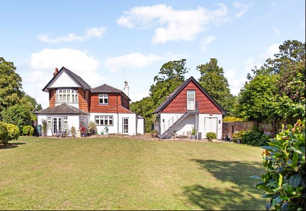 A substantial detached five-bedroom home with a self contained studio annex set within gro