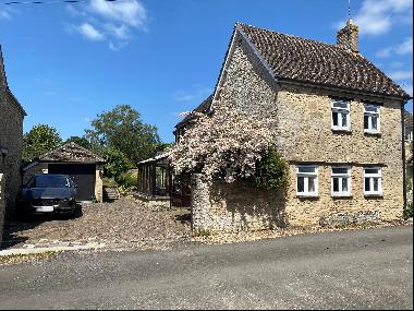 Built of Cotswold stone under a tiled roof, the house has been sympathetically extended ov