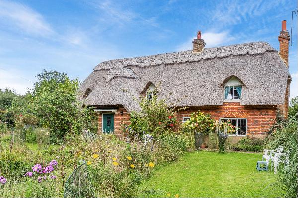 A very pretty Grade II listed, detached and thatched cottage in need of modernisation and 