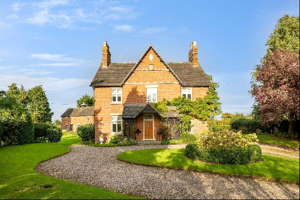 A period farmhouse with outbuildings set in lovely gardens with adjoining paddock - in all