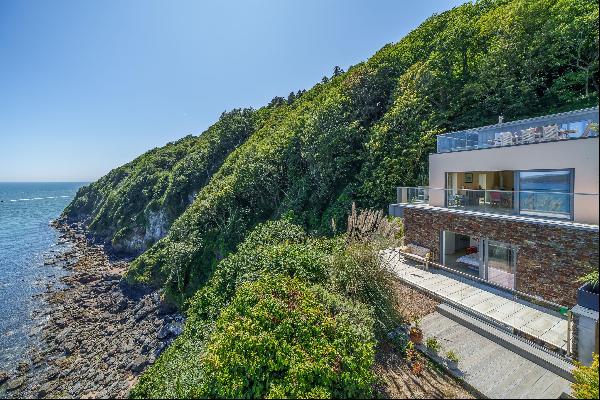 A contemporary masterpiece with panoramic waterfront views and direct water access.