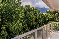 Apartment with windows and a balcony that face the treetops