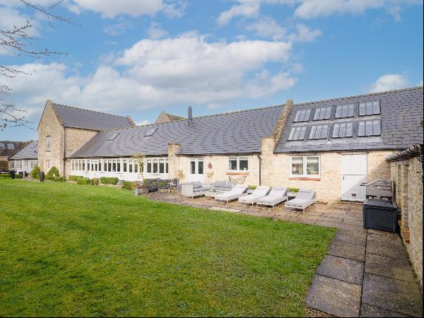 A spacious five bedroom Cotswold stone converted barn with over 5,000 sq ft of flexible li