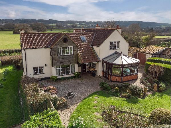 A detached south facing family cottage in stunning grounds with lake, and a range of outbu