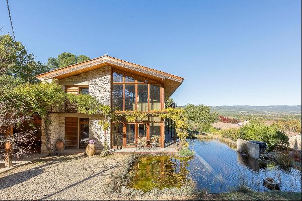 Stone bioclimatic house with pool and outbuildings.
