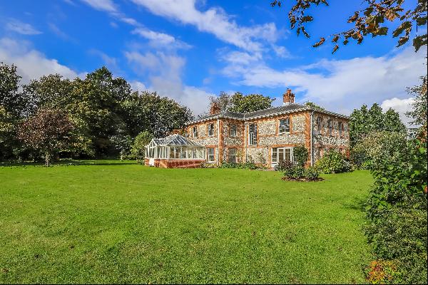 A beautifully renovated traditional Hampshire brick and flint farmhouse with a south-facin