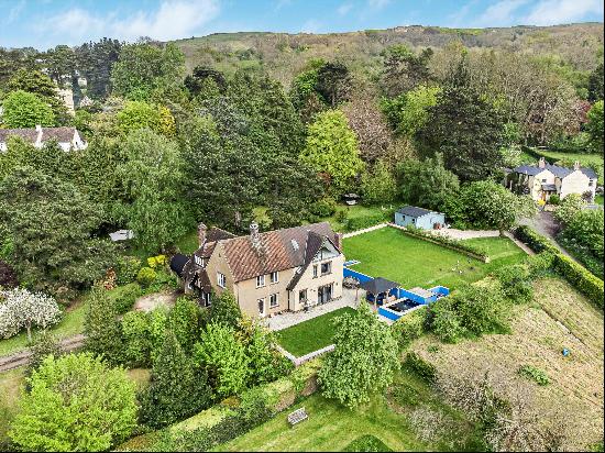 NO ONWARD CHAIN - Set under the stunning wooded backdrop of Cleeve Hill, in mature gardens