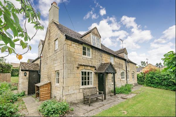 An immaculate detached stone cottage with pretty gardens, parking and garaging located on 