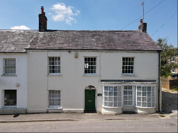 A Georgianised 17th century cottage with garaging and a partly walled garden situated in a