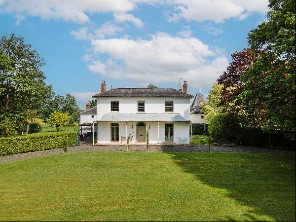 A fine Georgian house with extensive outbuildings, equestrian facilities and land in a qui