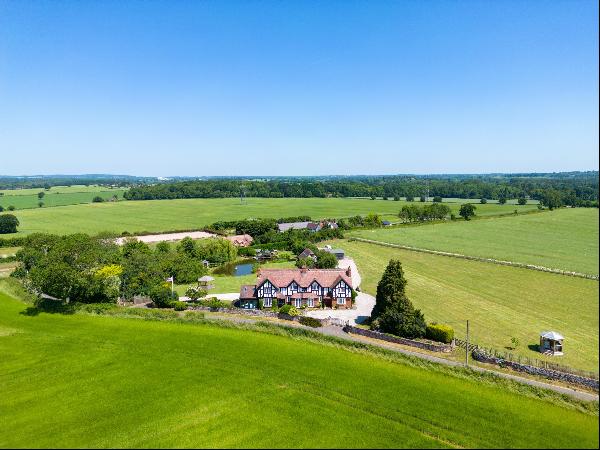 A substantial country house standing in an elevated position with beautiful grounds extend