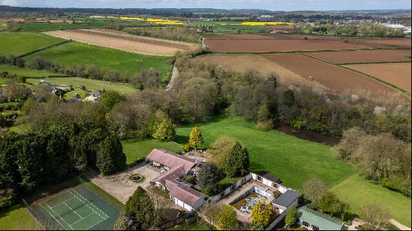 A spacious 4/5 bedroom detached house, with mature gardens, tennis court and land.