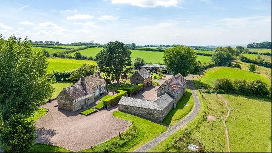 A restored Grade II listed farmhouse and two cottages, including a range of immaculate per