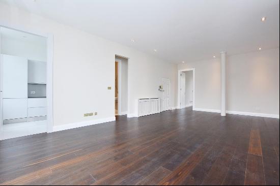 A beautifully refurbished apartment with two balconies and a communal garden.