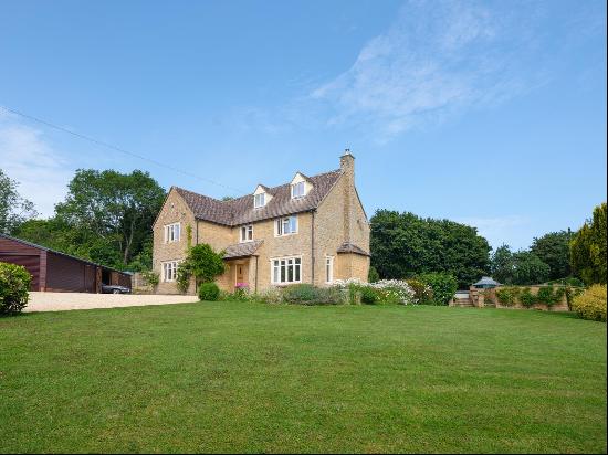 A secluded Cotswold stone village house in an elevated position overlooking Withington vil