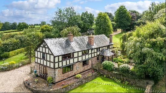 A well-maintained former farmhouse with land and versatile outbuildings.