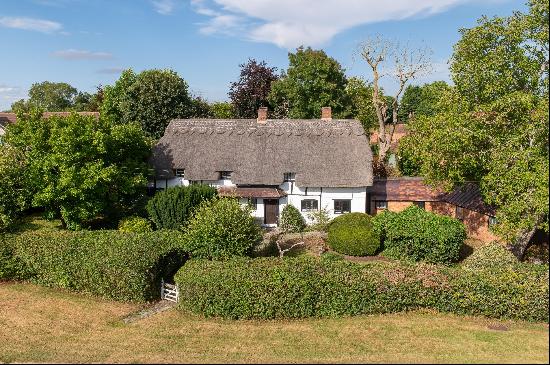 A lovely unspoilt listed detached four bedroom thatched cottage overlooking the village gr