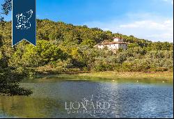 Luxury villa with a huge garden overlooking the lake for sale on Tuscan hills