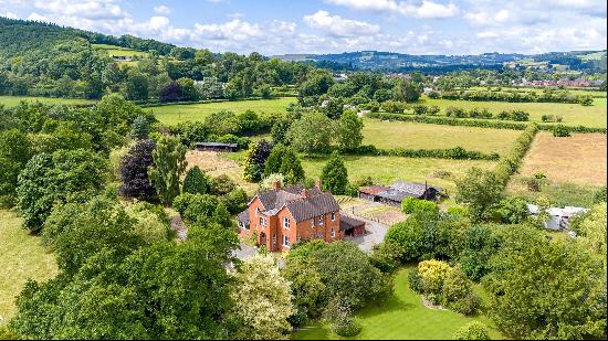 An attractive Edwardian house with useful outbuildings set in six acres of gardens and pad