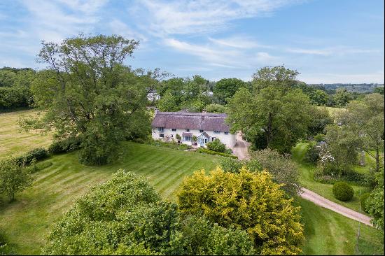 An attractive, south-facing 15th century farmhouse set in 12.69 acres amidst beautiful, un