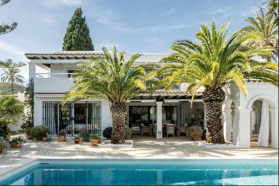 A charming villa with a lush garden and a swimming pool.