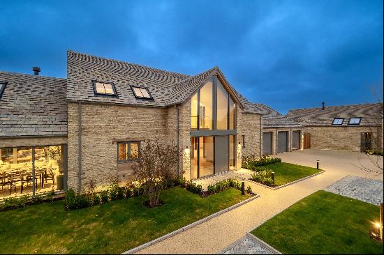 A contemporary four bedroom barn style home set within a gated and landscaped courtyard, s