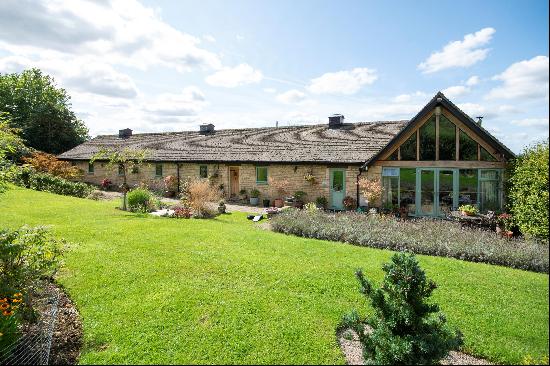 A superb single storey barn conversion set at the very foot of the Cotswold escarpment, on