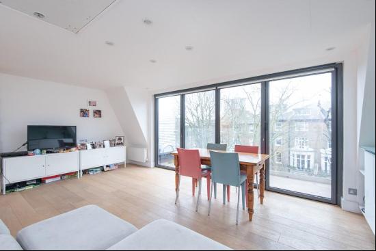 A modern top floor apartment with a large balcony.