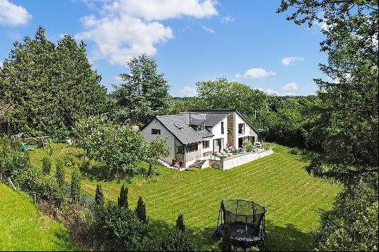 A contemporary and well-designed family home set within private gardens.